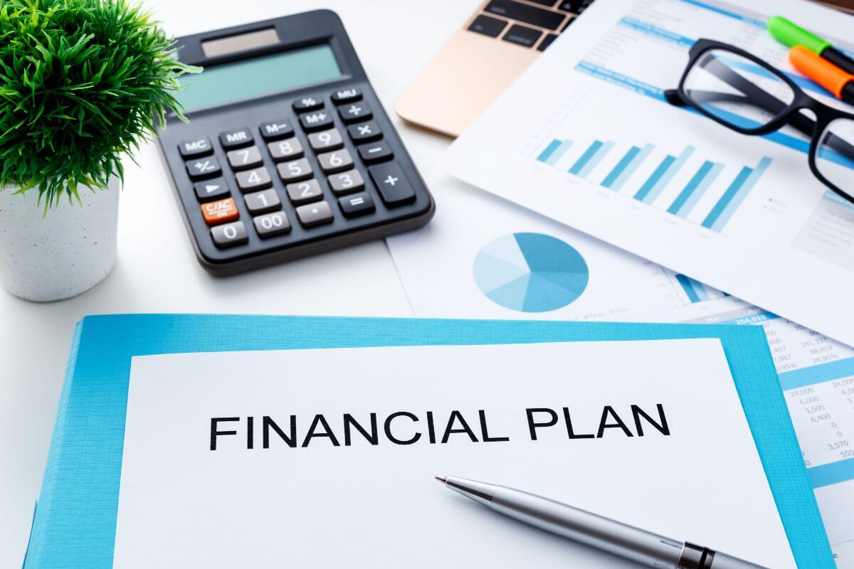 The image shows a plant, a calculator, an eyeglass, papers with graphs, a pen, and a piece of paper with notes referring to a good advisor who focuses on long-term financial planning to ensure your wealth grows steadily over time.