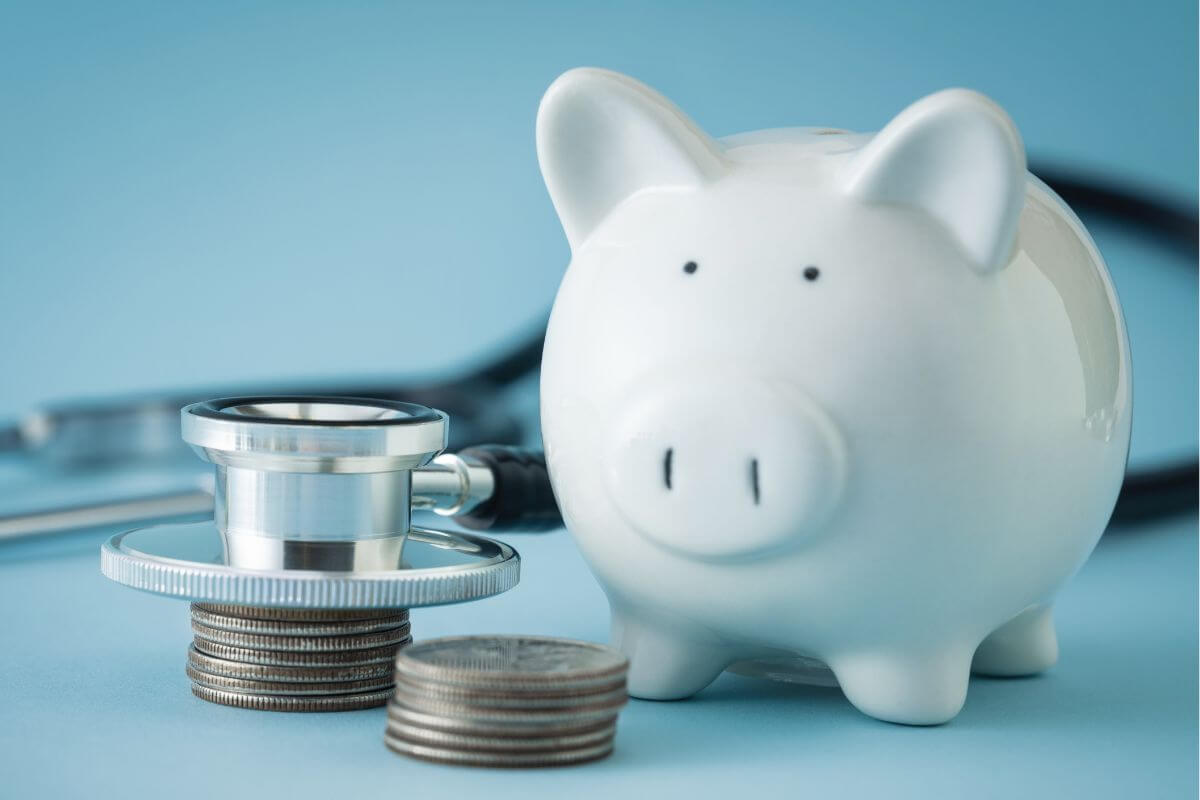 The picture tells about a stethoscope, coin stocks, and a piggy bank indicating how to account for healthcare and other future expenses in savings to ensure you're ready for future medical expenses.