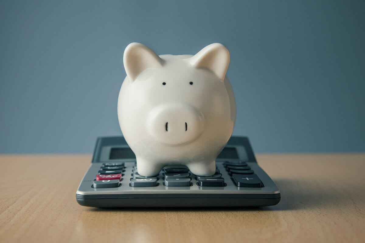 The image of a calculator and a piggy bank which means tools or calculator can help assess if on track to make financial planning easier.