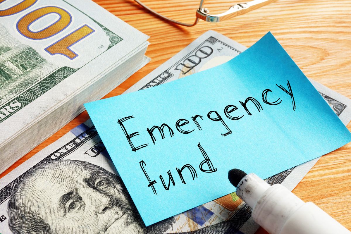 Image of money and a paper with emergency fund wording.