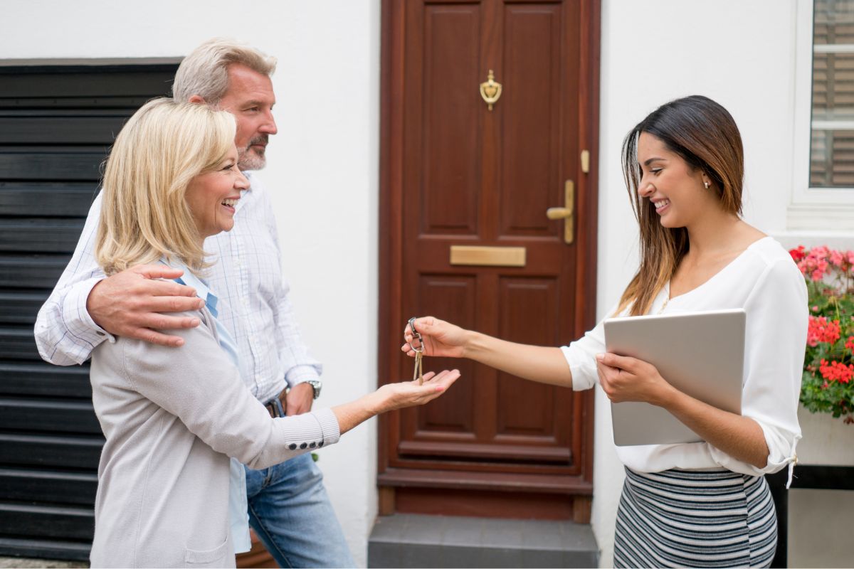 Picture of a real estate agent giving the key to the couple.