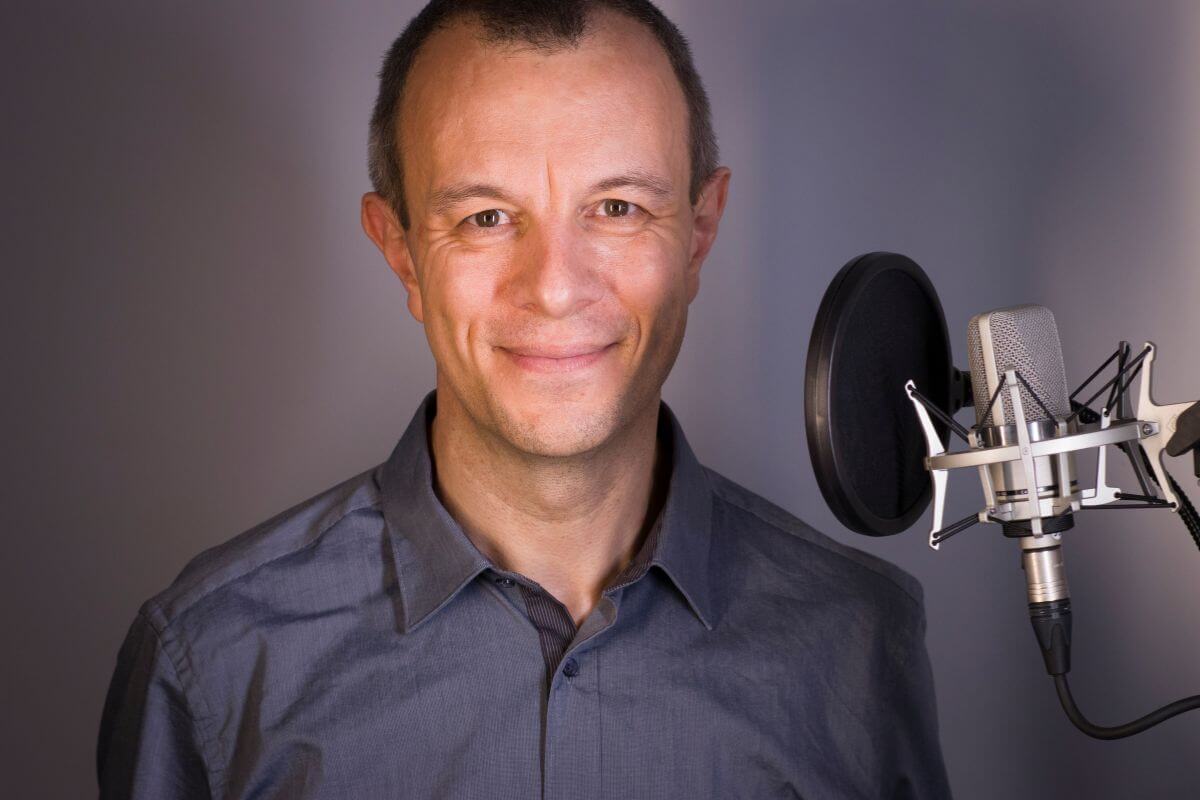 The image shows a microphone and a voice-over artist which refers to can earn over $50 an hour by lending their voice to commercials and more.