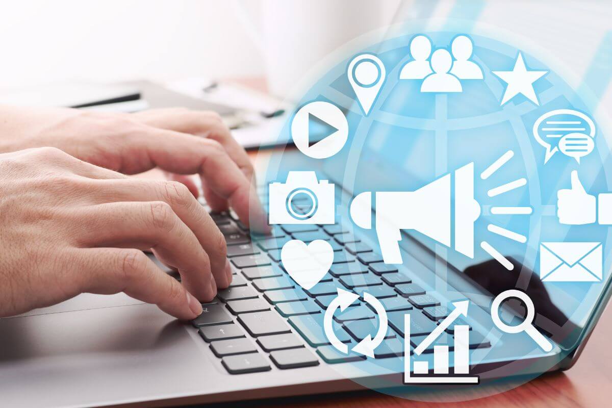 The photo tells about a man's hand using a laptop with digital icons on the screen referring to digital marketers earning over $50 an hour which an ideal for tech-savvy individuals looking to boost their earnings.