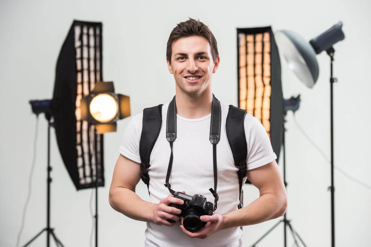 The photo of lighting tools behind and a photographer carrying a backpack and a camera which means they earn $50 an hour capturing special moments or creating stunning visuals/
