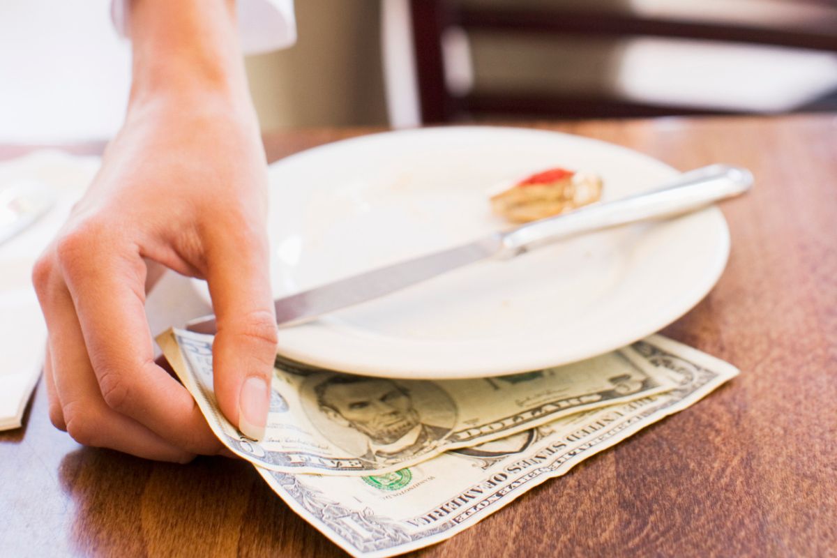 Image of a waitress picking her tips.