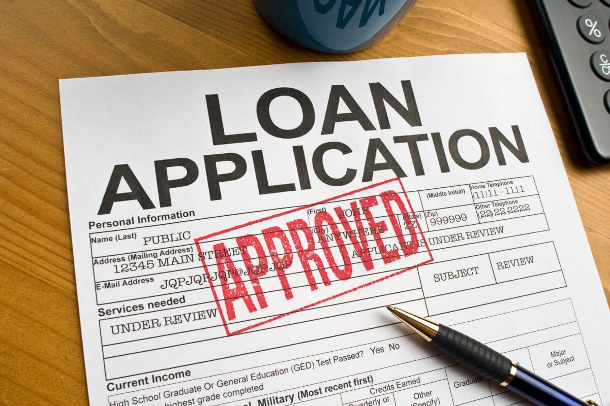 The image tells about a calculator, a pen, and a piece of paper with notes and a red stamp which means avoiding taking on new debt helps you focus on building a strong financial foundation.