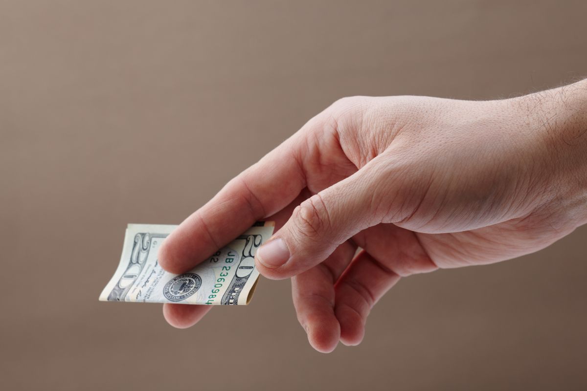 The picture shows a man's hand showing money.