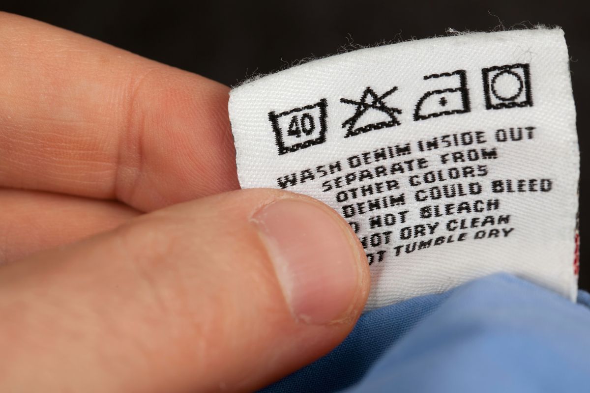 Image of a woman's hand checking the label of a shirt.