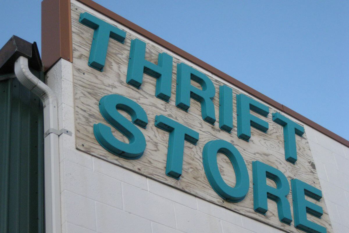 The photo shows signage on the wall referring to visiting thrift stores in affluent neighborhoods to find luxury goods at fractions of their original price.