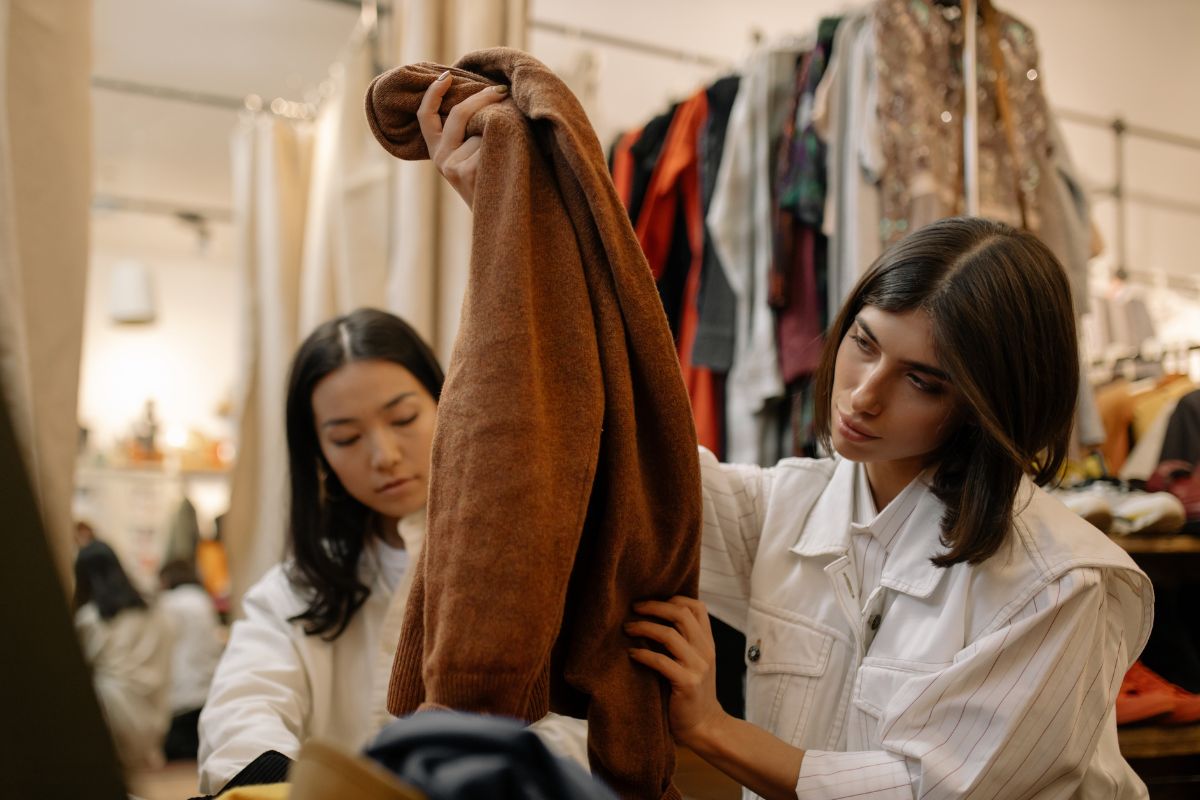 The photo shows a woman inspecting clothes.