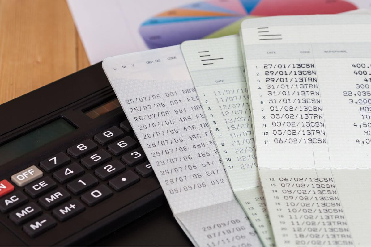 The picture shows a calculator, a paper with a graph, and bank books referring to designated beneficiaries on all financial accounts ensuring these assets bypass probate, saving time and money for your loved ones.
