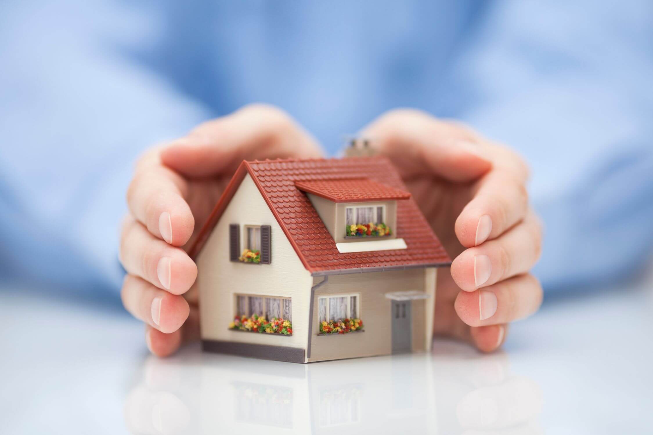 The photo tells about a man's hand holding a mini house figure which refers to avoiding co-owning property unnecessarily and helps avoid confusion and delays and ensuring your assets pass to the right people without unnecessary legal processes.