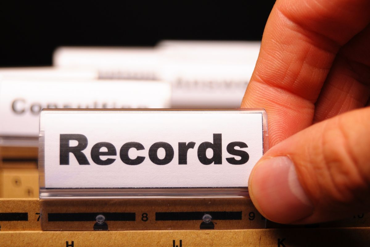 Picture of a man's hand pulling out records.