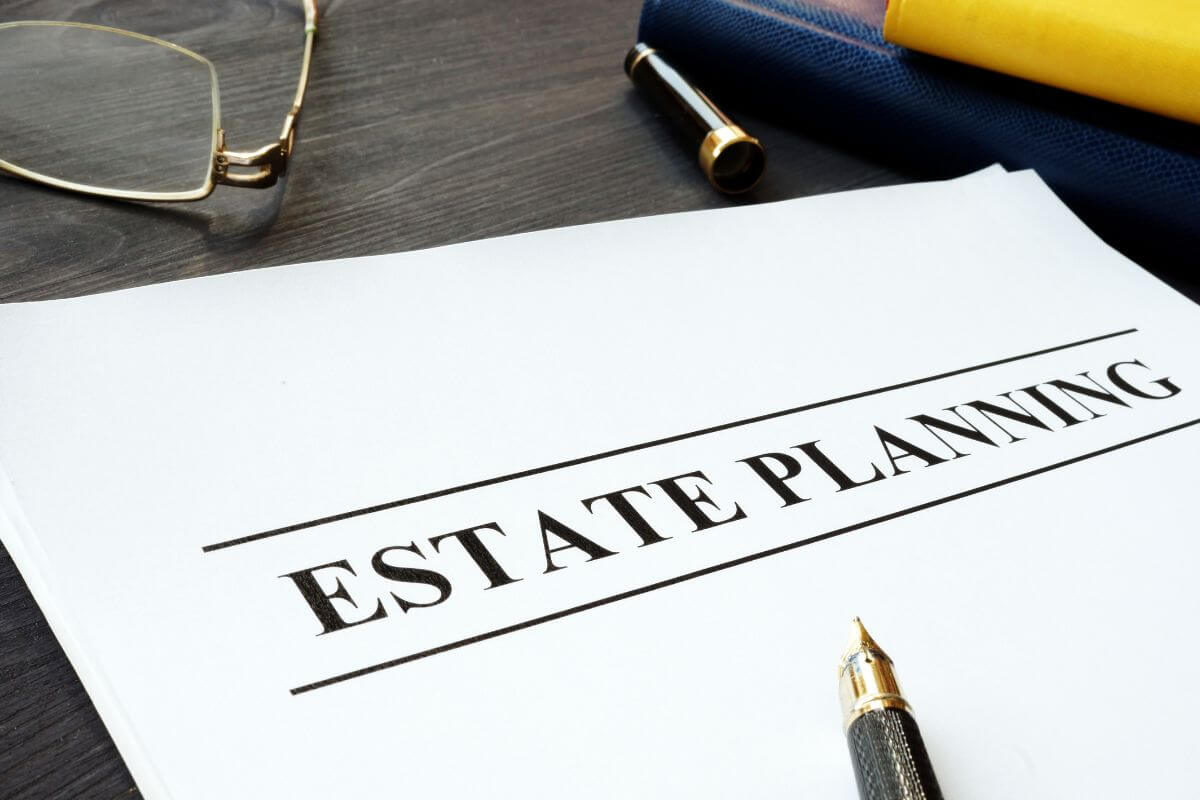 The picture shows an eyeglass, a pen, a notebook, and a piece of paper with notes indicating the steps to start estate planning now to ensure your assets are distributed according to your wishes.