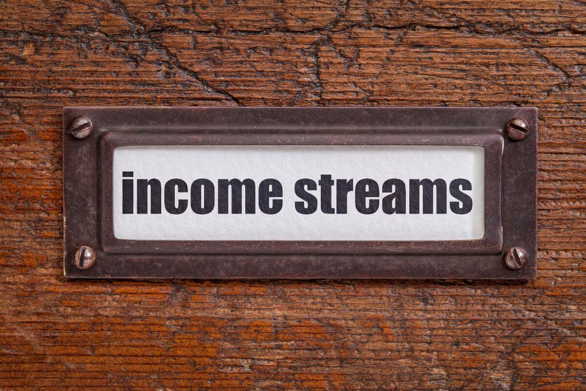 The photo tells about a metal tag with notes indicating that building multiple streams of income provides a safety net if one source falters.