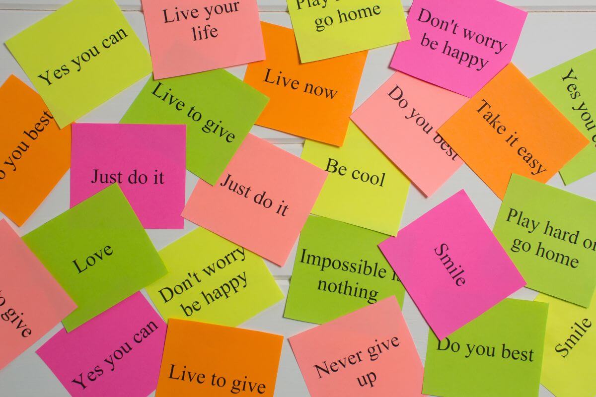 The picture tells about small papers with notes indicating that focusing on money affirmation statements can lead to better habits and decisions.