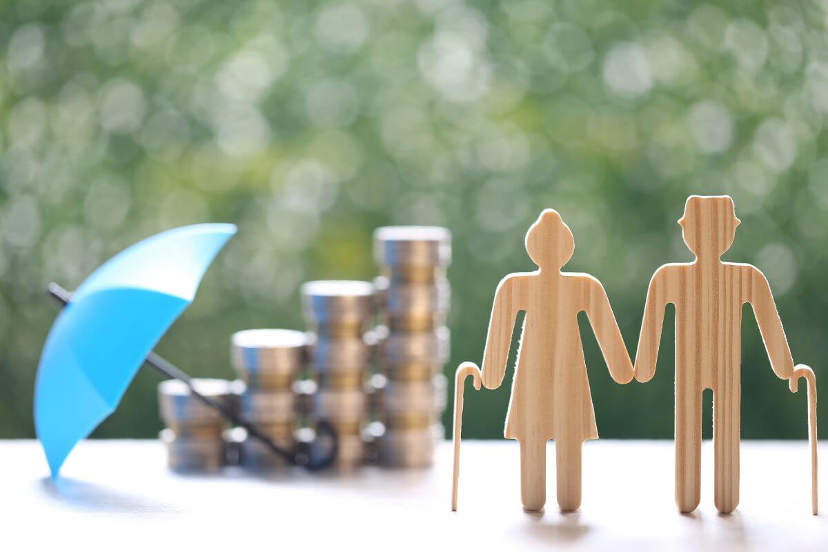 The photo tells about coin stocks, an umbrella, and a senior figure indicating that setting realistic retirement goals helps you stay motivated and on track and keeps your financial plan focused and achievable.