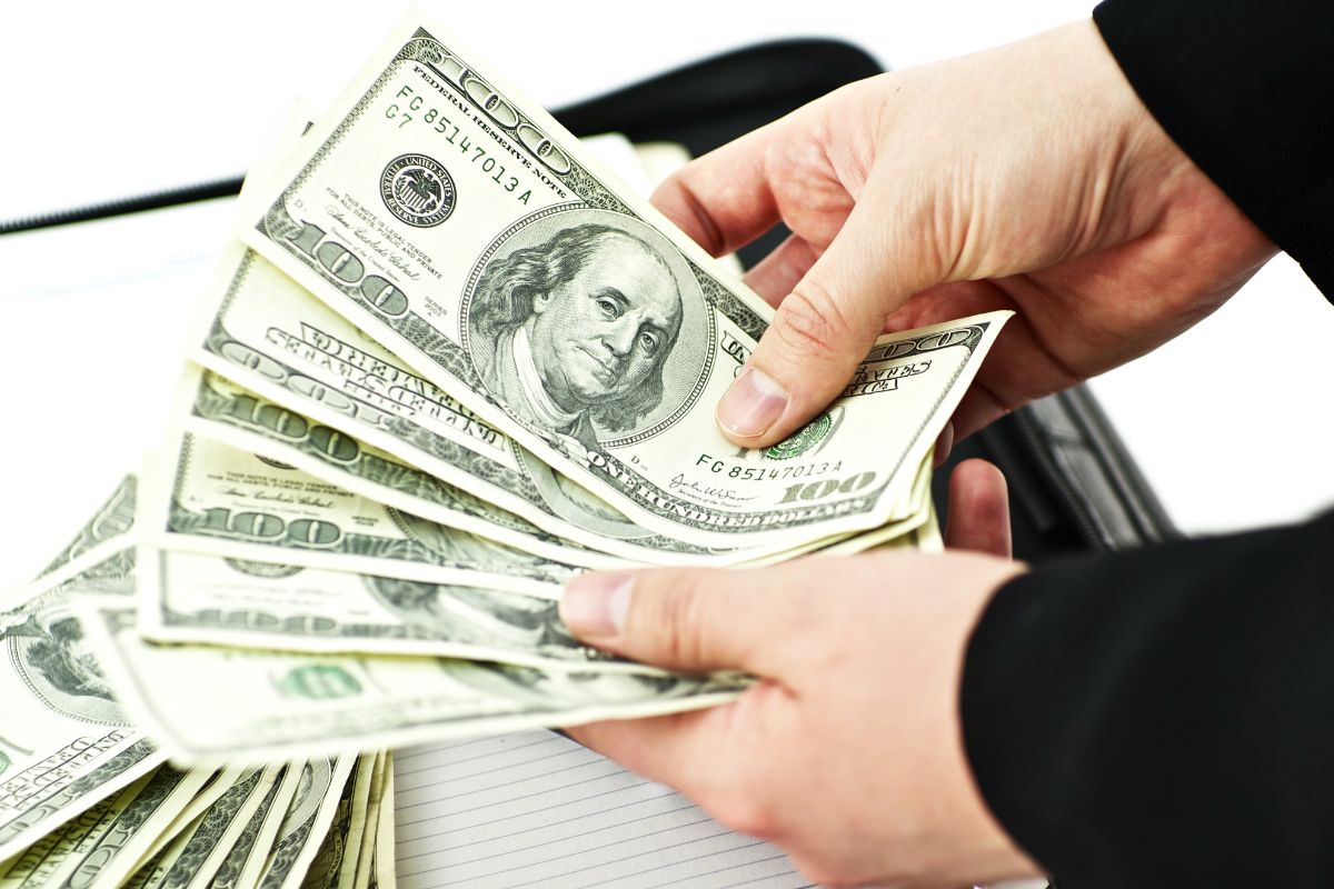 Image of a man's hand counting money.