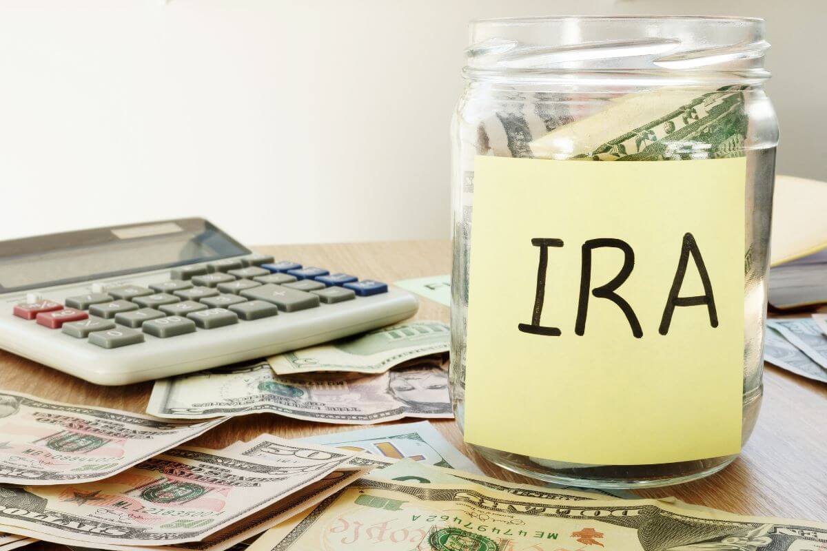 The picture shows a calculator, dollar bills on the table, and a jar filled with dollar bills with a note indicating to plan for taxes in retirement to reduce your tax burden.