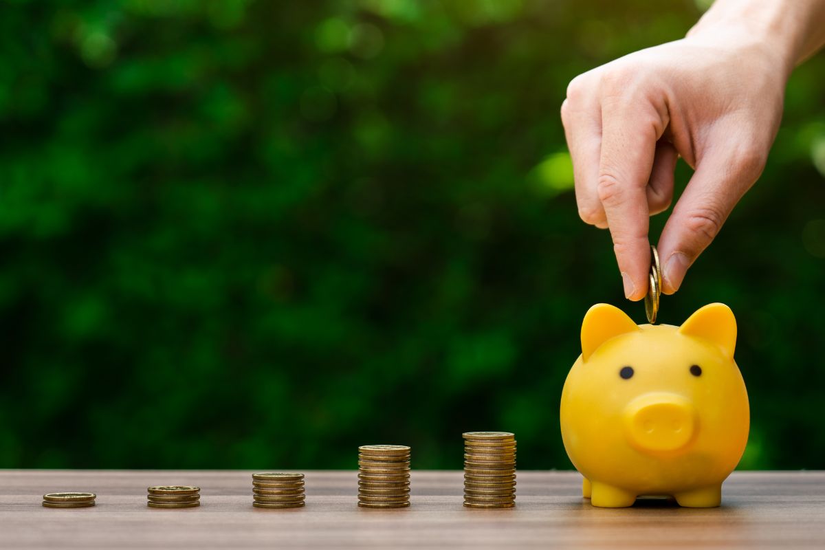 Photo of a man's hand saving money.
