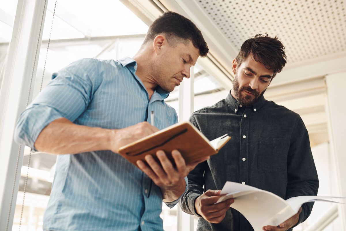 The picture shows men comparing their net worth.