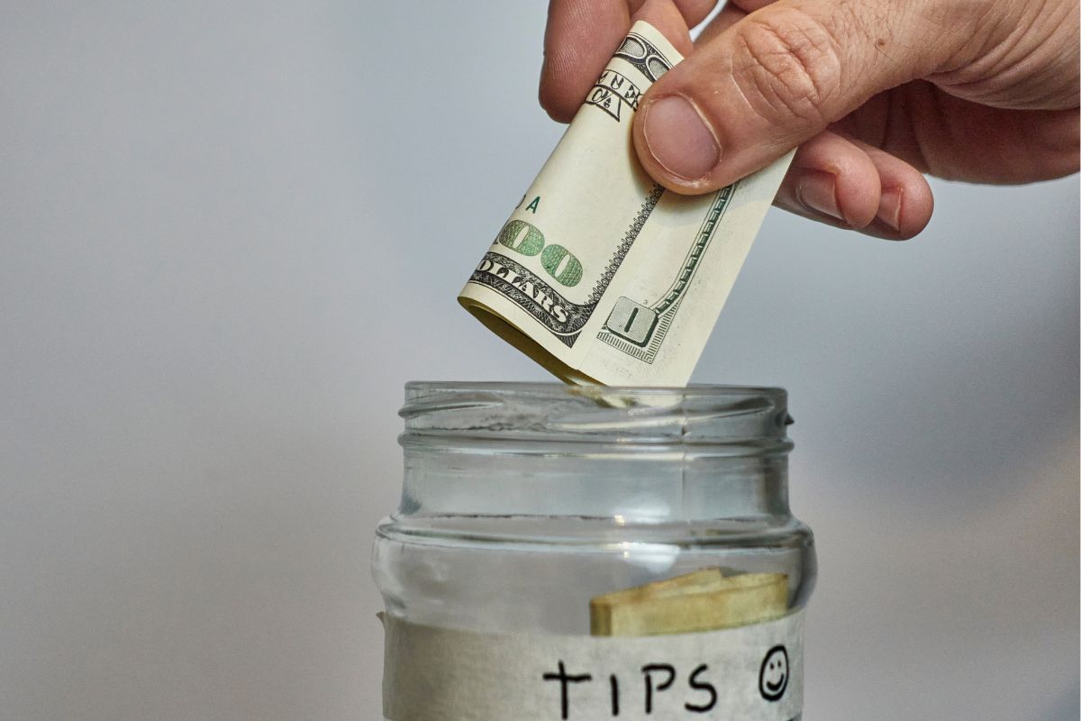 The image shows a man's hand and saving tips.