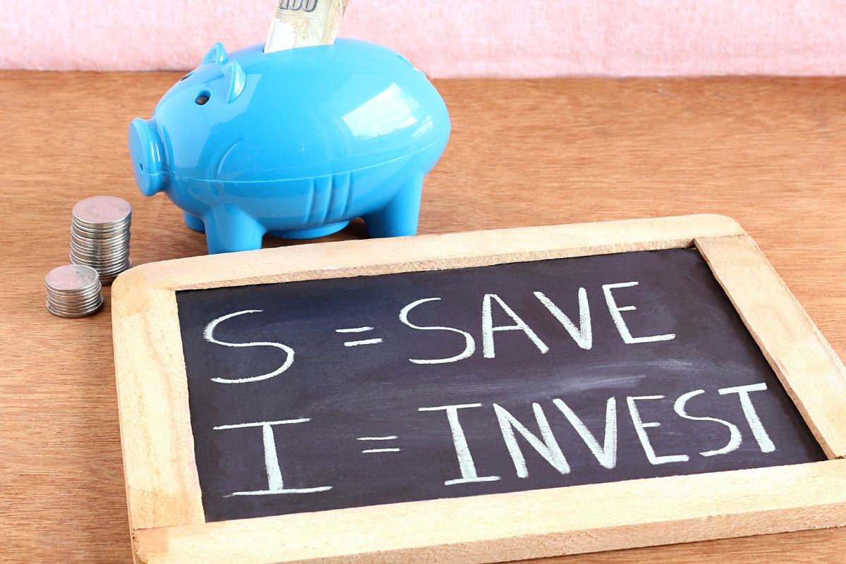 A piggy bank and board with save and invest wording.