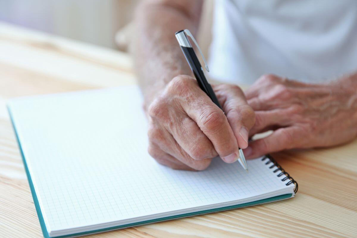 The picture of an old man's hand and writing on the notebook which means to list sentimental items with specific recipients there's no questions about who should keep them.