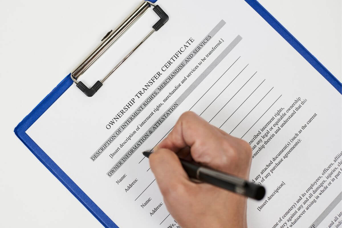The picture shows a clipboard with a piece of paper and notes, and a man's handwriting on it which means to clarify ownership and transfer of business interests make sure everything stays on track and the right people take control.  