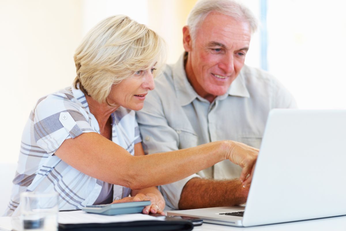 The picture shows a senior couple organizing their expenses.