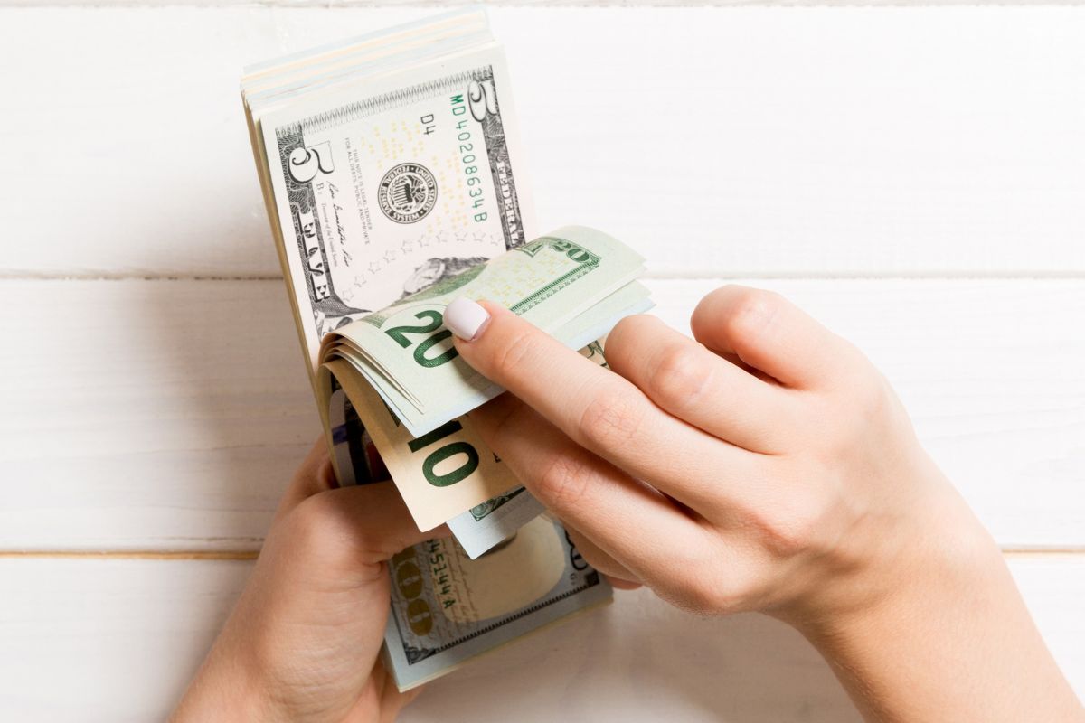 Image of a woman's hand holding money.