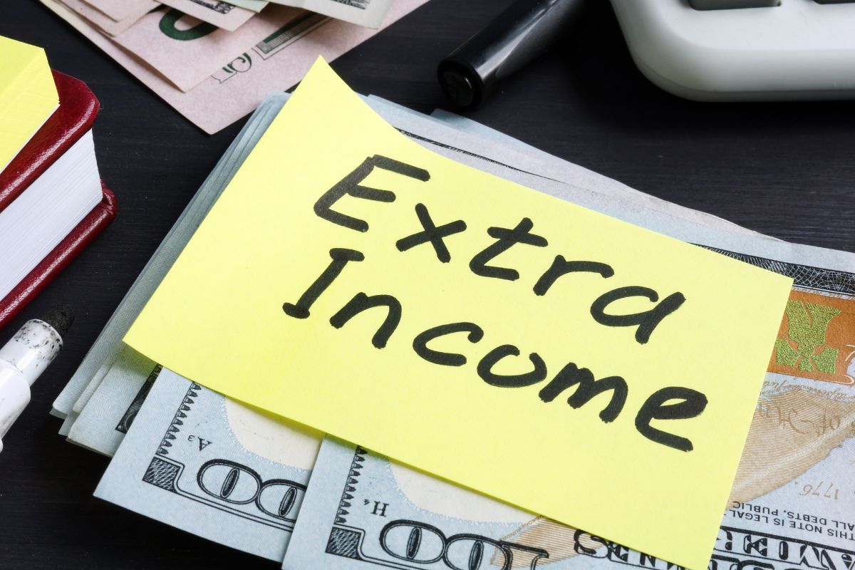 Picture of money and a paper with extra income written.