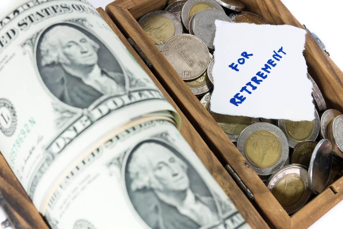 The image shows dollar bills, coins, and a piece of paper with notes in a wooden container indicating to save for retirement and every dollar saved can make a difference in the long run.