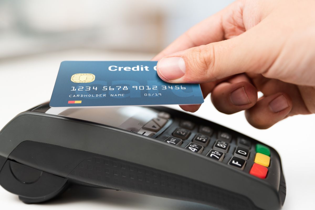 Photo of a woman's hand using a credit card payment.