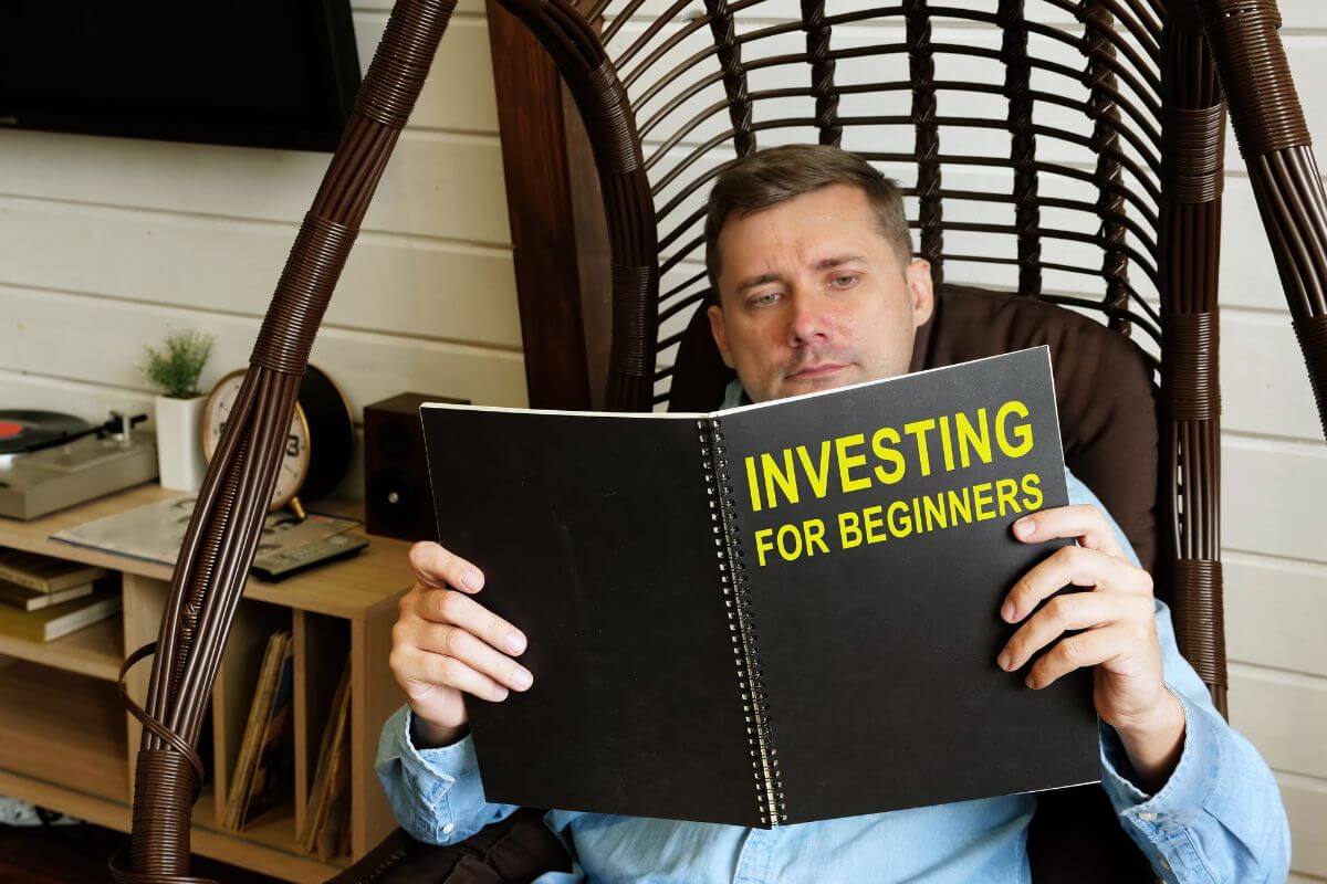 The picture of a man reading a book while sitting means educating yourself through free resources helps you feel more confident about your financial decisions.