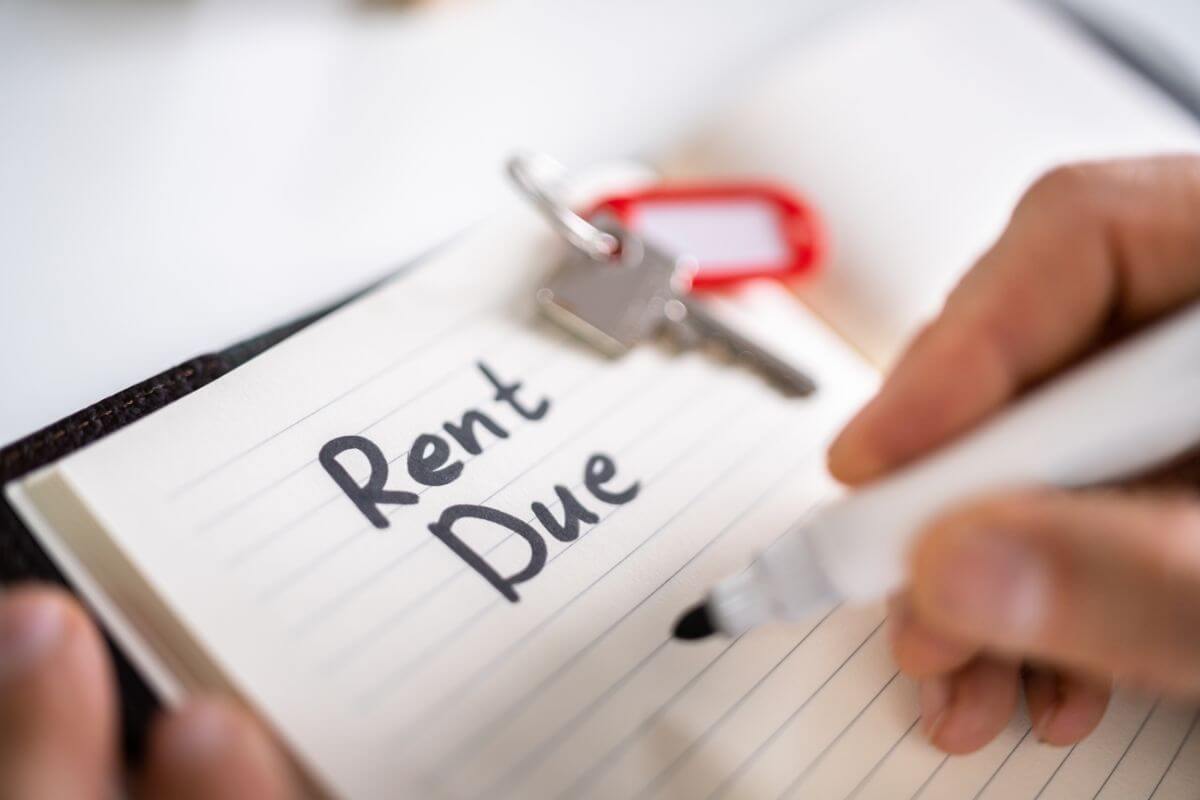 The picture of a house key, a notebook with notes, and a man's hand holding a marker which means to use rent-reporting services lets you turn those payments into positive credit history.