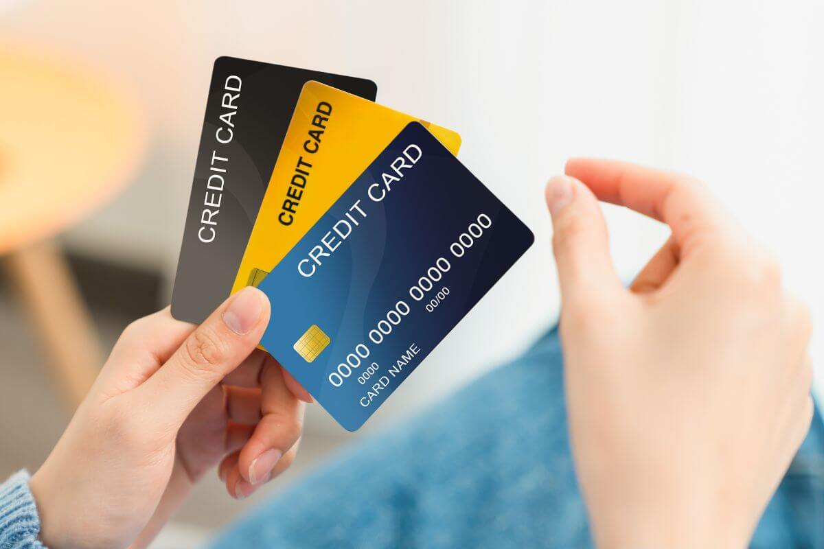 The photo shows a girl's hand holding cards indicating to gradually transition to unsecured credit cards as your credit improves and can further boost your credit if used wisely. 