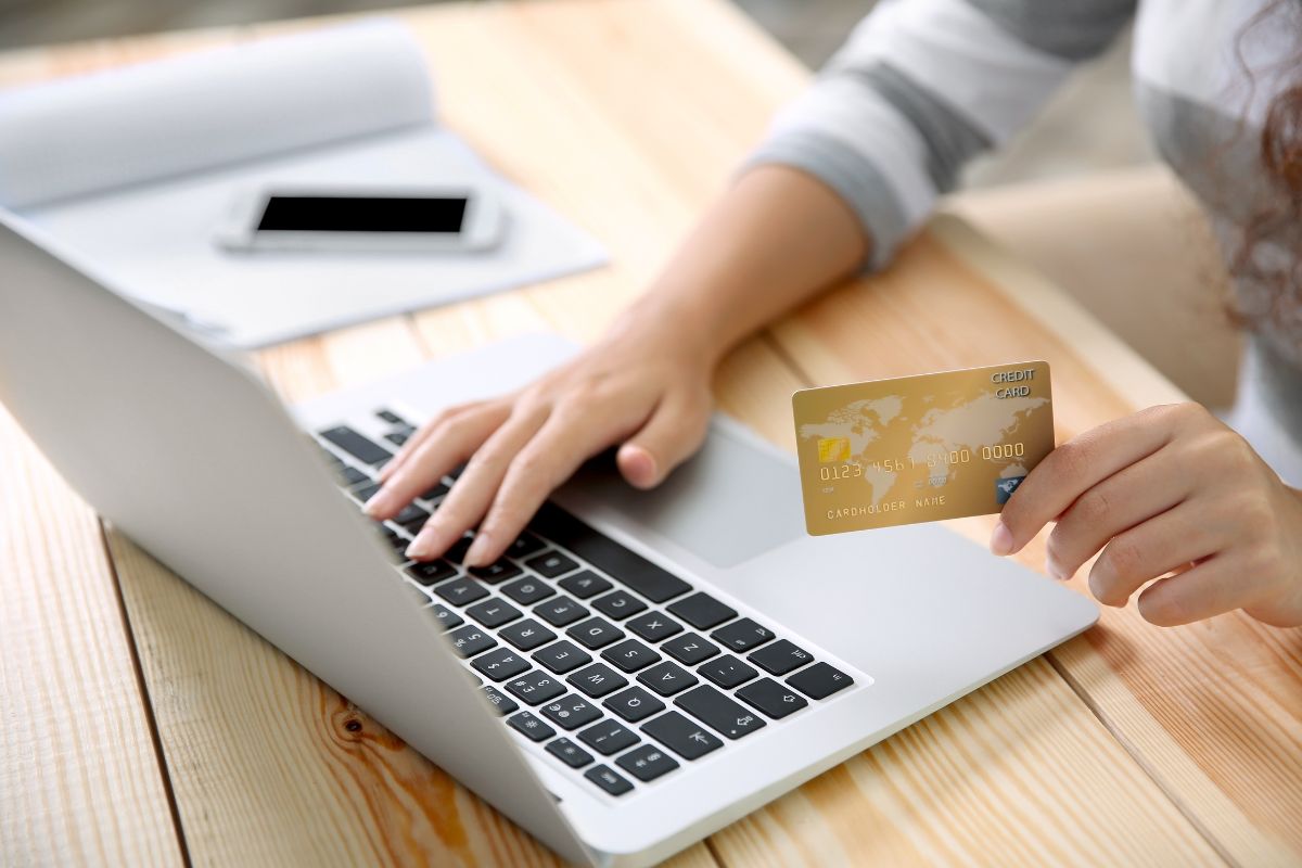 The image shows a woman's hand using a laptop.