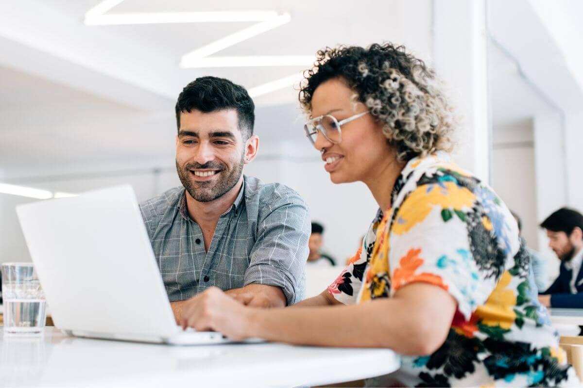 The photo tells about a financial advisor explaining the content of a laptop to her client referring to asking questions and seeking advice from trusted sources to help you avoid mistakes and feel more confident managing your money.