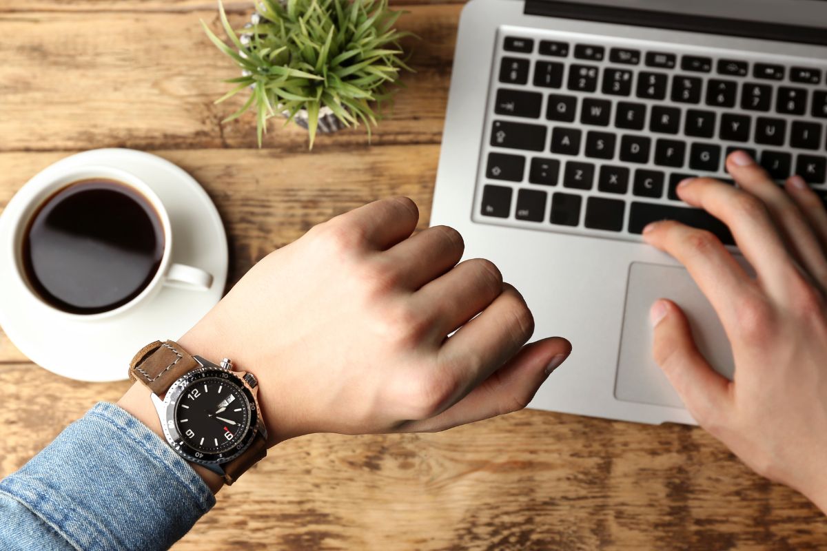 Image of a man checking his watch while wording.