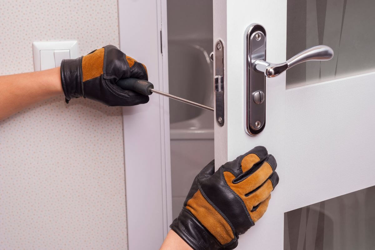 The image shows a man's hand repairing the door knob which means using community time banks helps you meet needs without touching your wallets.