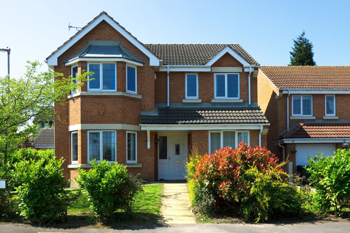 The image tells about plants and a house referring to exploring house-sitting opportunities for free housing in between or looking to reduce expenses.