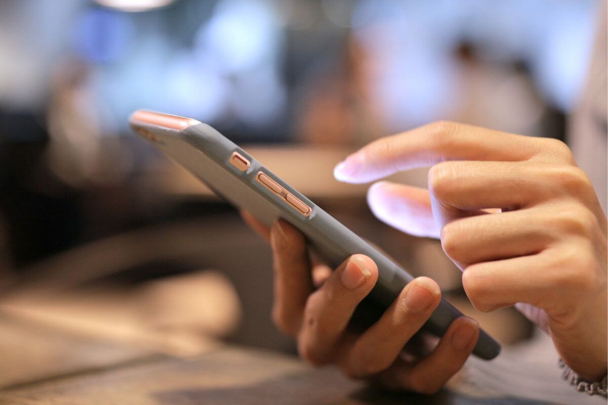 The image tells about a girl's hand using a smartphone which refers to a downsized phone to cut costs.