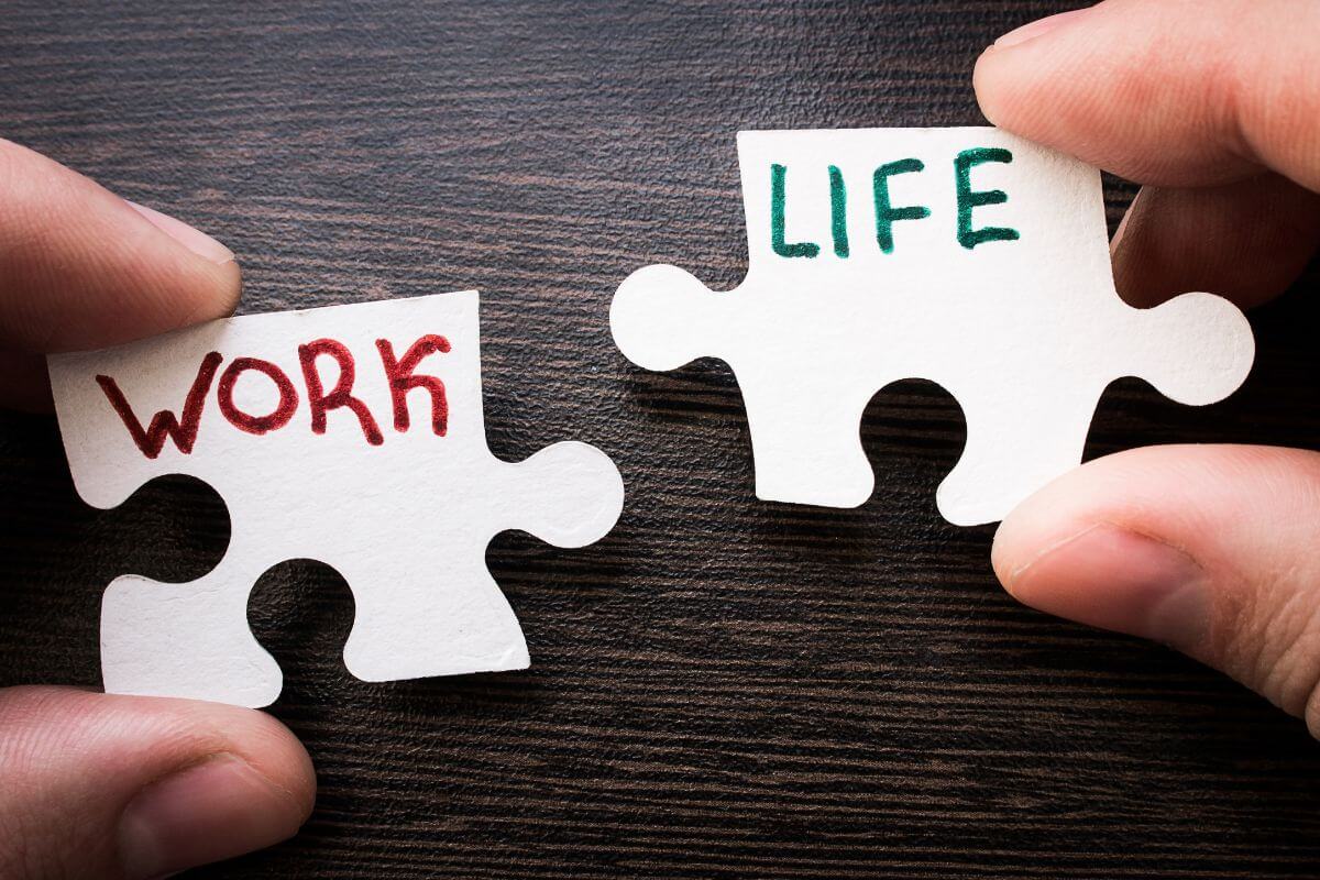 The image tells about puzzles with notes and holding by a man's hand referring to work on achieving a better work-life balance helps you handle stress and focus on priorities. 