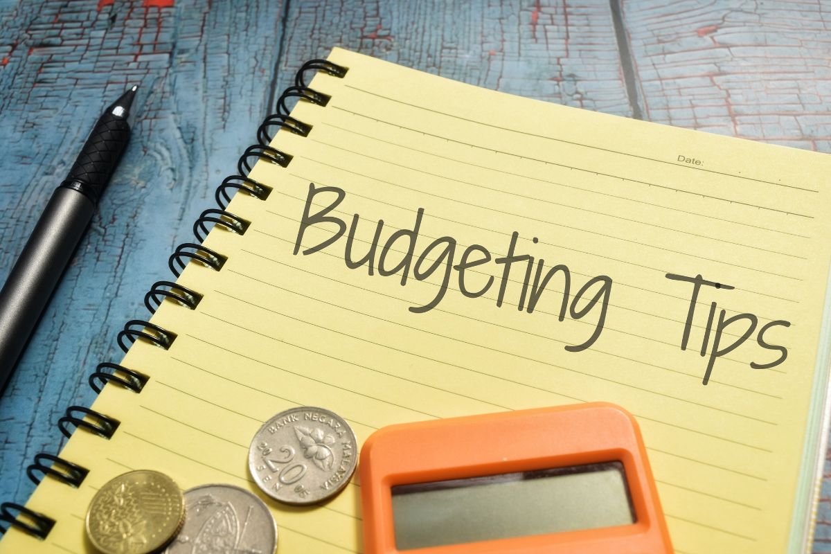 The image shows a notebook with budgeting tips written.