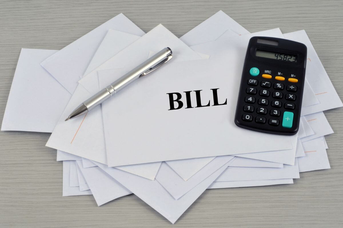 The picture shows envelopes with a note, a pen, and a calculator referring to negotiating bills for better rates to take control of your finances without changing your lifestyle.