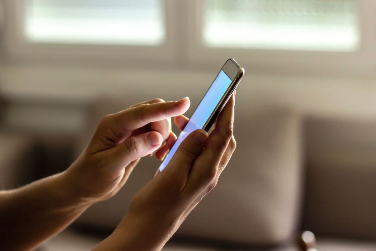 The image tells about a girl's hand using a phone indicating that apps with in-game purchases add up fast to your expenses, avoiding these can save money.