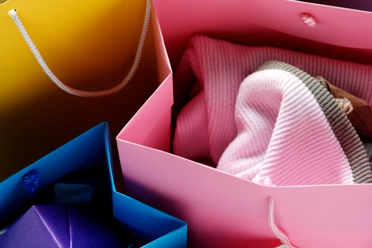 The image shows shopping bags with clothes inside which means endless knick-knacks from gift shops usually just collect dust, skipping this to avoid clutter and saving money.