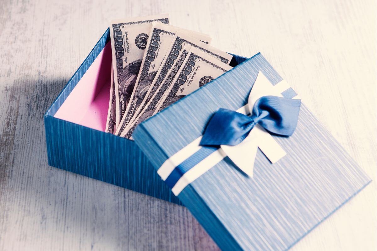 The image shows a gift box with dollar bills indicating that saving half of all gift money and allowance in a high-yield savings account helps teens grow their money faster with interest.