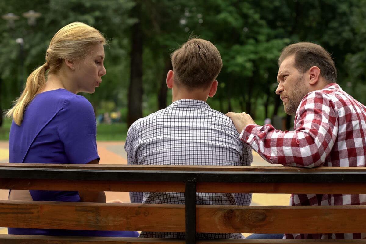 The picture shows parents talking to their teen son referring to starting now with this solid financial advice can help their kids build confidence, responsibility, and independence when it comes to managing money.